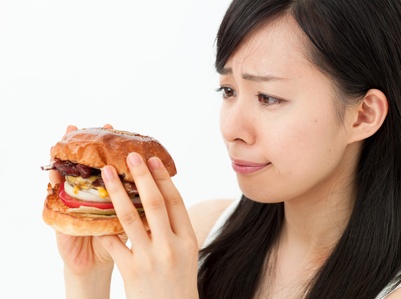ハンバーガーを食べようとして考える女の子
