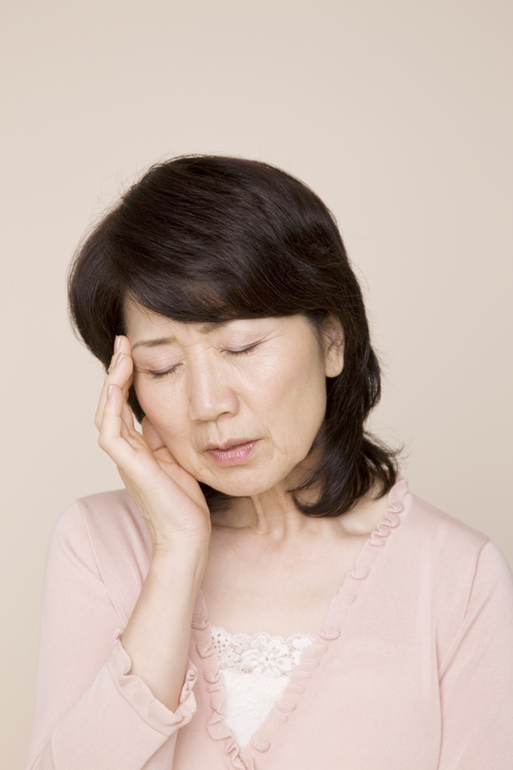 頭を押さえて俯いている女性