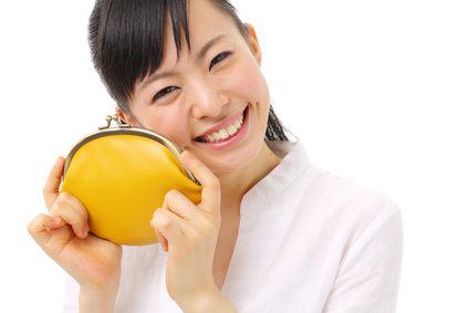 笑顔で黄色い財布を持つ女性