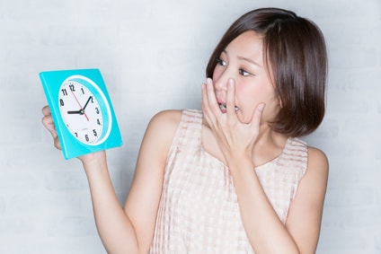 時計を見て焦る女性