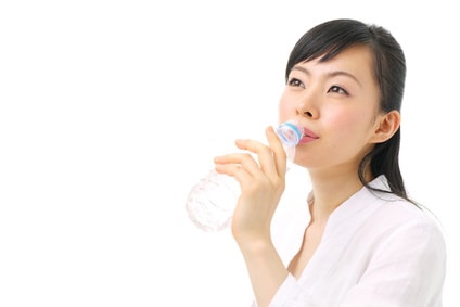 ペットボトルの水を飲む女性