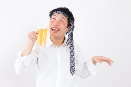 ビールを手に持ち頭にネクタイを巻いている酔っぱらいの男性