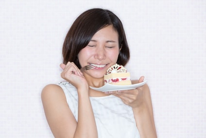 ケーキを食べて喜んでいる女性