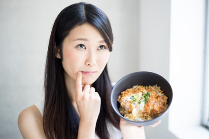 かつ丼を食べようか迷っている女性