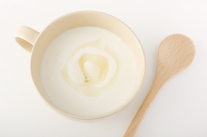 ヨーグルトにオリゴ糖を入れているコップとスプーン