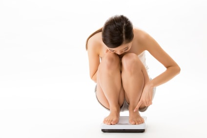 体重計に乗って確認している女性