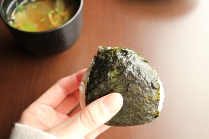 のりを巻いたおにぎりを持つ