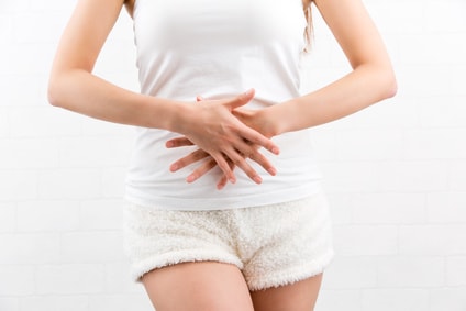 下腹部を手でおさえる女性