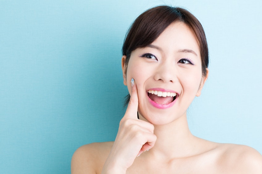 頬の弾力を一刺し指で確かめる女性