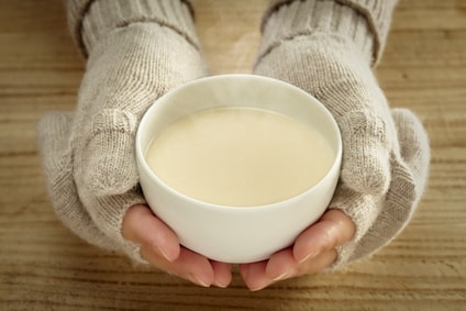 甘酒を両手で持つ